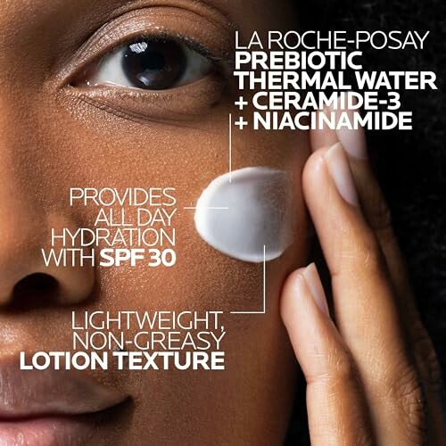 Close-up of person applying moisturizer with SPF 30 on face.