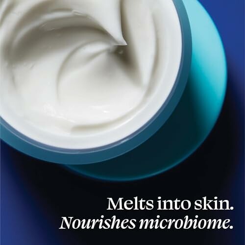 Closeup of skincare cream in a jar with text 'Melts into skin. Nourishes microbiome.'